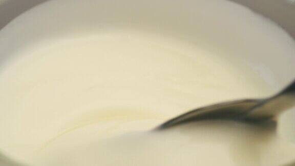 用勺子在杯子里搅拌酸奶