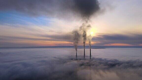 从空中俯瞰火力发电厂的高管道黑烟在日落时向上移动污染空气