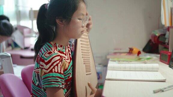 小女孩在弹琵琶(中国的琵琶一种带有微动指板的拨弦乐器)