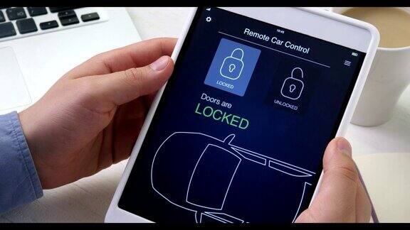 一名男子使用数字平板电脑上的汽车遥控应用程序远程锁车