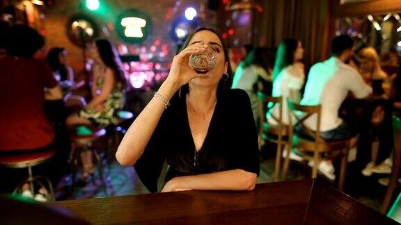 年轻漂亮的女人独自坐在酒吧里喝酒