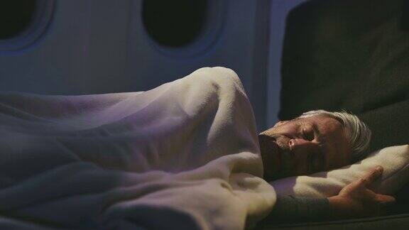 在私人飞机上睡觉的成熟商人