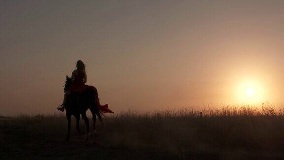夕阳西下红衣女子骑马的剪影