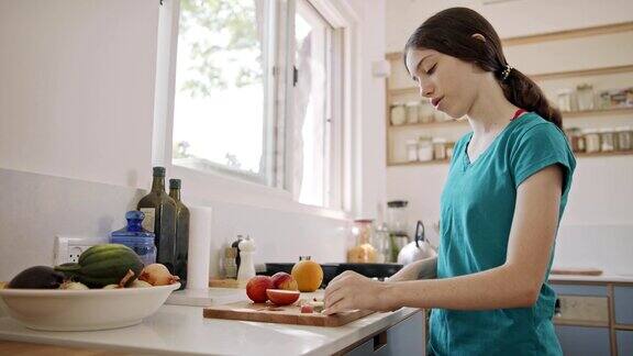 十几岁的女孩在厨房切水果做早餐