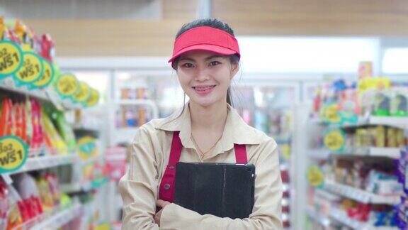 有吸引力的年轻女售货员站在超市看着相机微笑的肖像