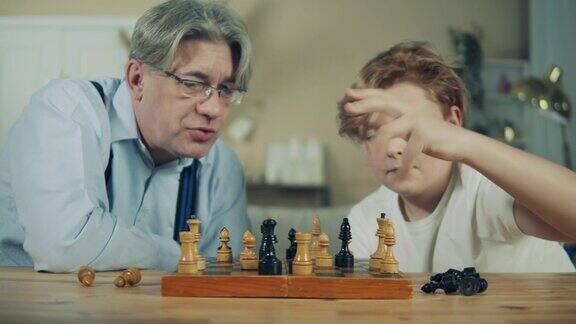 老人和他的孙子正在密切注视着棋子