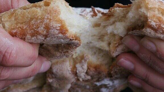 用手掰开刚烤好的面包的慢动作特写