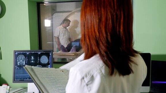 身着白大褂的女性放射科专家看着病人接受CTMRI检查并在检查x光时写下医疗结果珀森被磁共振成像扫描仪扫描高清