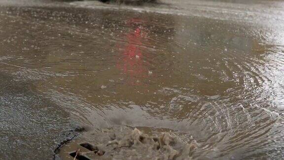 雨水落在路上流过下水道汽车在被水淹没的道路上行驶