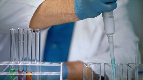 科学家用手将液体样品倒入试管中实验室设备