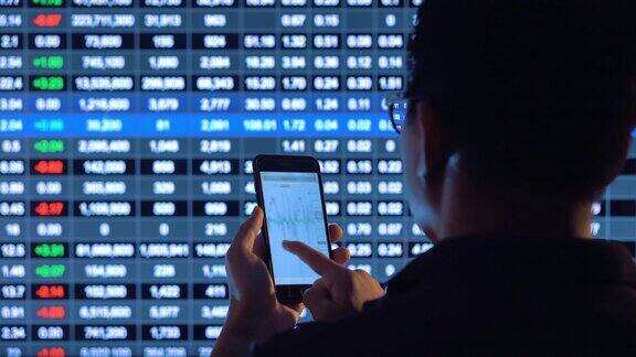 商人看智能手机和股票市场金融屏幕