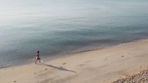 女人在海滩上跑步的鸟瞰图