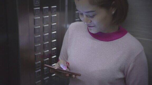 年轻女子在电梯里使用智能手机