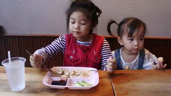 两个亚洲小孩在餐厅吃饭