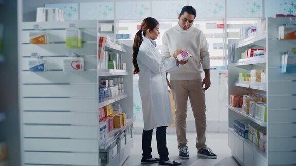 药店:女性亚洲药剂师帮助印度男性客户与推荐并建议购买药物药物维生素现代药店货架与保健产品