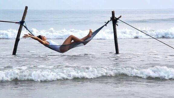 在沙滩上的吊床上放松的女人
