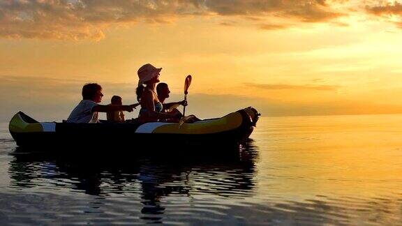 一家四口在日落时玩皮划艇