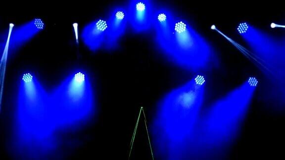 明亮闪烁的音乐会聚光灯激光和烟雾在现场背景