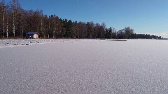在一个阳光明媚的冬日里瑞典结冰的湖面被白雪覆盖