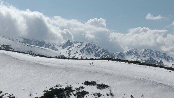 无人机拍摄的登山运动员徒步旅行的雪山脊