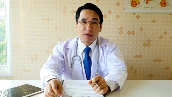 在视频聊天中亚洲医生看着摄像机说话