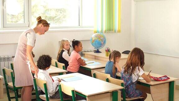 老师在教室里帮助孩子们完成家庭作业