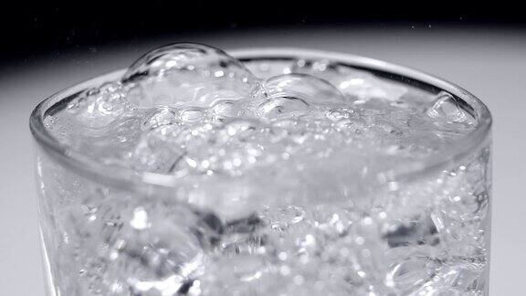 将透明苏打水倒入加冰的玻璃杯中慢动作库存镜头
