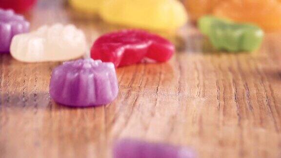 彩色糖果在木桌上跳舞真实的慢动作近距离