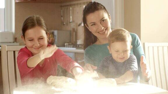 微笑快乐的家庭在厨房玩面团一起做饼干