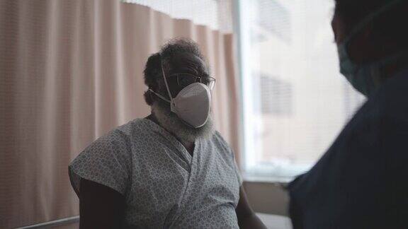 护士戴着防护口罩在病房与病人交谈