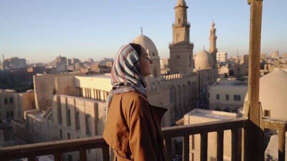一幅戴着头巾的妇女从屋顶俯瞰开罗的肖像