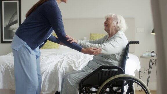 护士帮助老奶奶坐在轮椅上