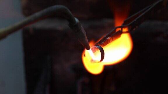 金匠珠宝商使用火炬加热金金属戒指的制作过程