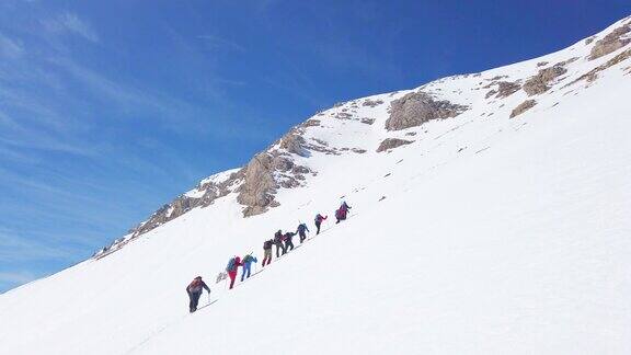 冬季高山登山队在高海拔的山峰上连续向上移动