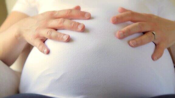 孕妇抚摸着自己的肚子高清