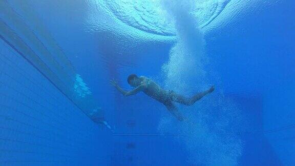 SLOMOLD男性潜水员降落在水池中向水面游泳