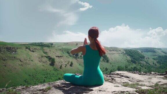 运动女孩在莲花位置练习瑜伽美丽的山景