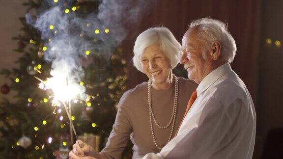 一对老年夫妇在圣诞夜用烟花跳舞