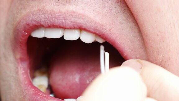 特写一个人用牙线用塑料牙签刷牙