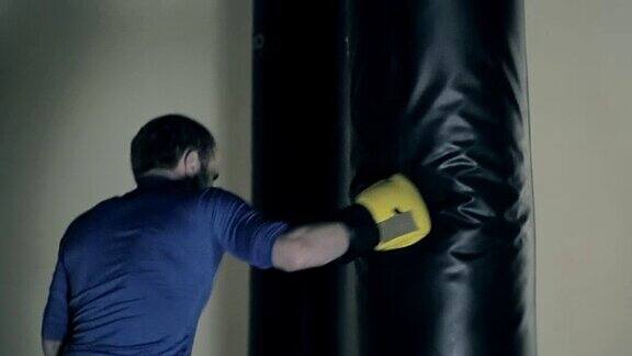 运动员在赛前进行训练拳击手用拳头击打沉重的袋子黑色背景