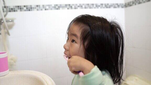 一个在浴室刷牙的亚洲女孩