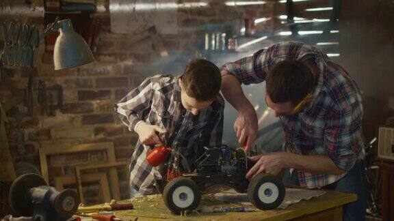 父子俩正在家里的车库里修一辆无线电控制玩具车