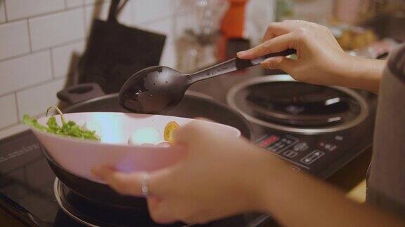 亚洲妇女在家里做东百胜开泰国菜