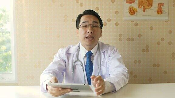 男医生在他的办公室里与病人进行视频通话
