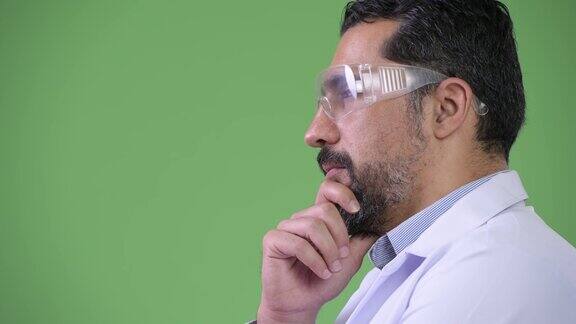 侧面的英俊的波斯胡子男子医生戴着防护眼镜和思考