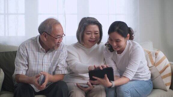 一名亚洲女性用数码平板电脑向一名亚洲年长女性授课