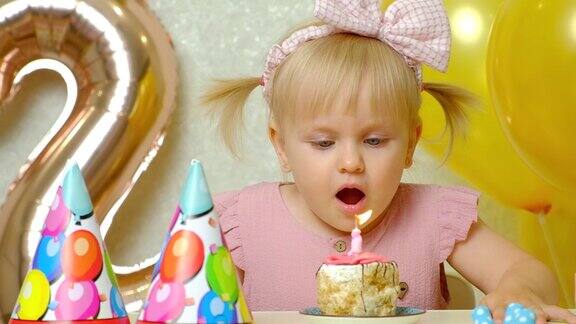 一个两岁的小女孩吹灭了生日蛋糕上的蜡烛许了一个愿