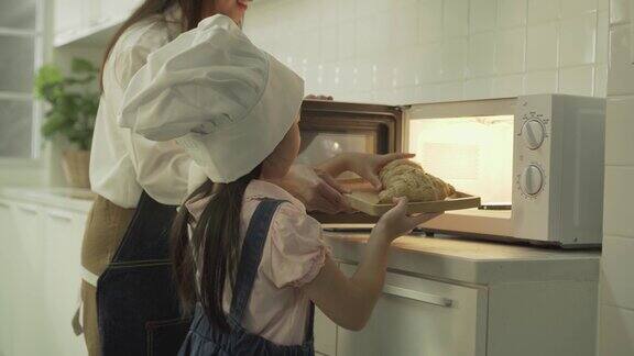 亚洲小女孩在厨房帮妈妈烤面包