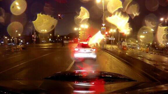 快速城市行驶夜间道路POV时间推移的挡风玻璃和车罩雨夜雨滴在玻璃上