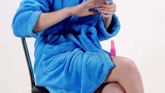 十几岁的女孩穿着蓝色浴衣画指甲与粉红色指甲油